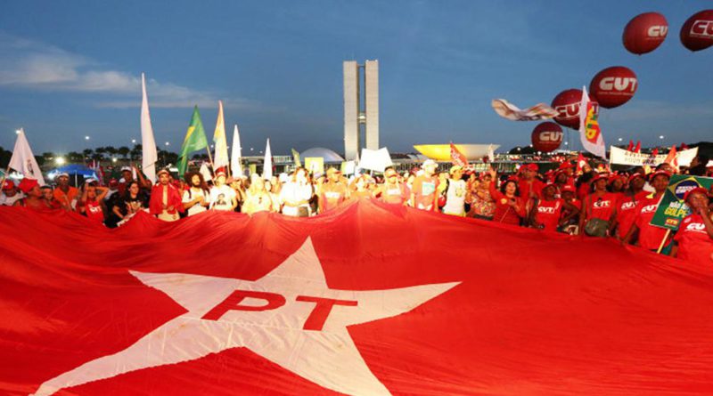 Povo segurando a bandeira do PT em Brasilia